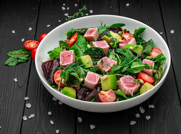 Japanese traditional salad with pieces of mediumrare grilled Ahi tuna and sesame with fresh vegetable on a bowl