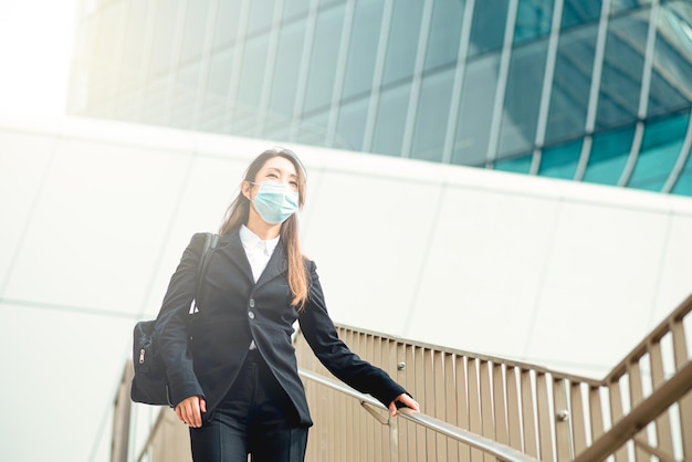 Japanese woman broker Asian expert in high finance while walking in the skyscraper neighborhood of the stock exchange symbol of equality in professions and womens rights successful career