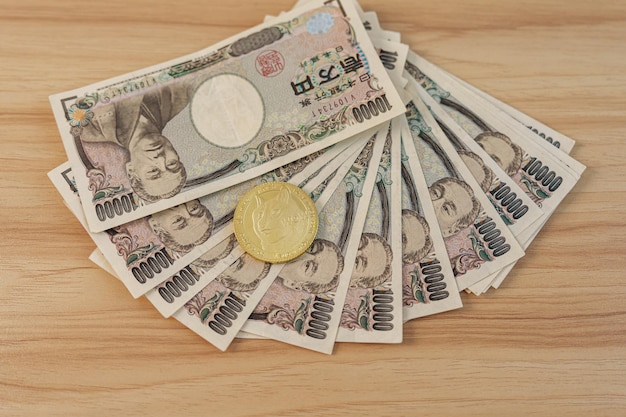 Japanese Yen banknote with gold Dogecoin cryptocurrency on table Japan cash Tax Recession Economy Inflation Crypto Investment and Decentralized Financial concepts