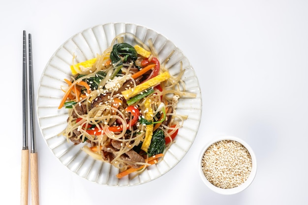 Japchae is stir-fried Korean vermicelli noodles with vegetables and slices beef.