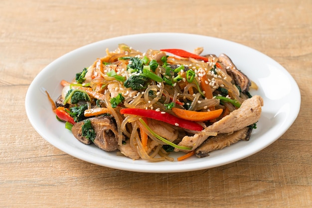 Japchae or stirfried Korean vermicelli noodles with vegetables and pork topped with white sesame  Korean traditional food style