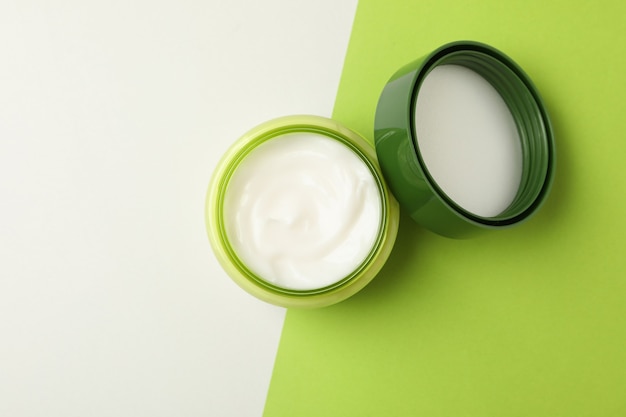 Jar of cosmetic cream and leaves