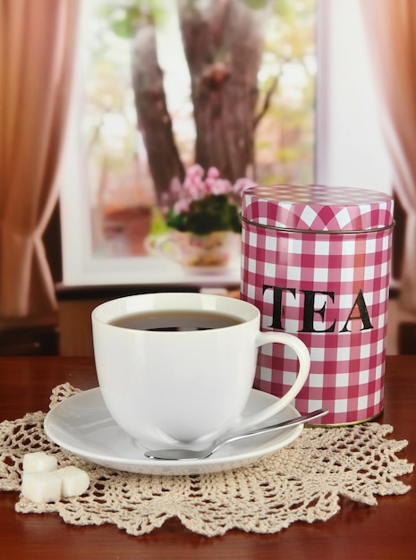 Jar and cup of tea on table in room