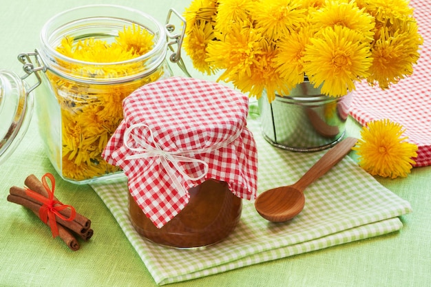 Jar of dandelion jam cinnamon and blowball flowers