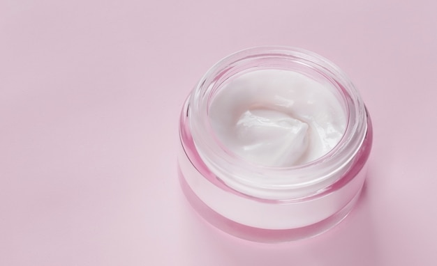 Jar of face cream on a pink background