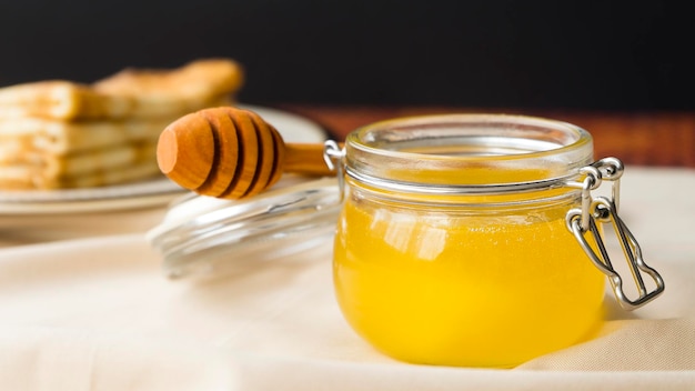 A jar of fresh fragrant honey on the table Image with selective focus