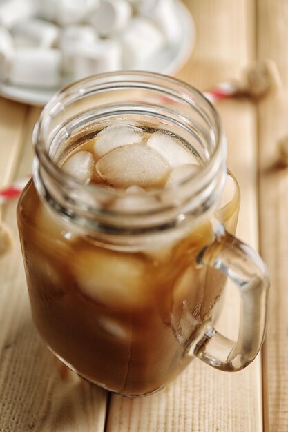 Jar of ice coffee on wooden table