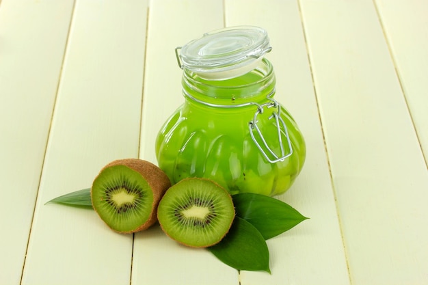 Jar of jam kiwi on wooden table closeup