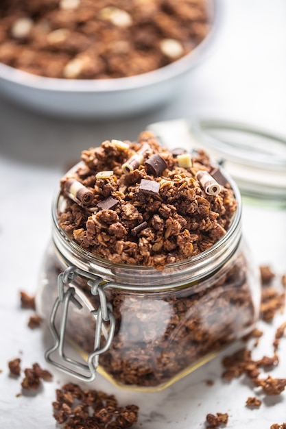 Jar of muesli with dark and milk cocolate pieces - closeup.