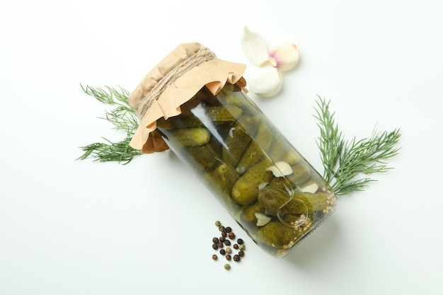 Jar of pickles and ingredients on white background