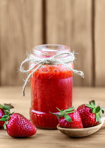 A jar of strawberry jam on the table.