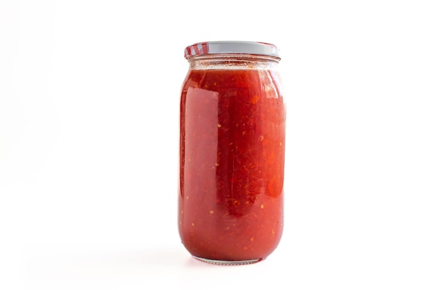 Jar of tomato sauce isolated on white background. Closeup photo of homemade tomato sauce.