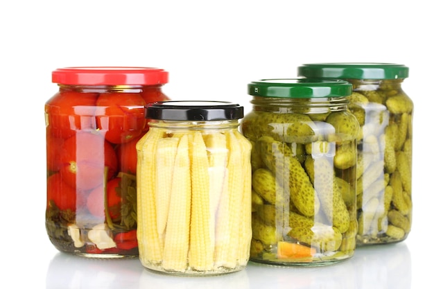 Jars of canned vegetables isolated on white