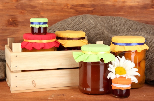 Photo jars with canned fruit on wooden background