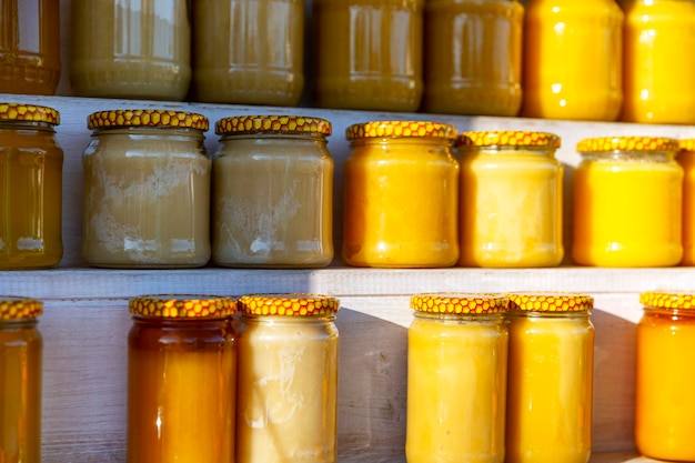 Jars with different honey on the shelves at the market Healthy eco products