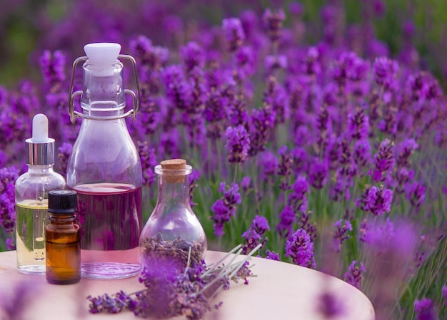 Jars with lavender oil lavender flowers on the background of a lavender field