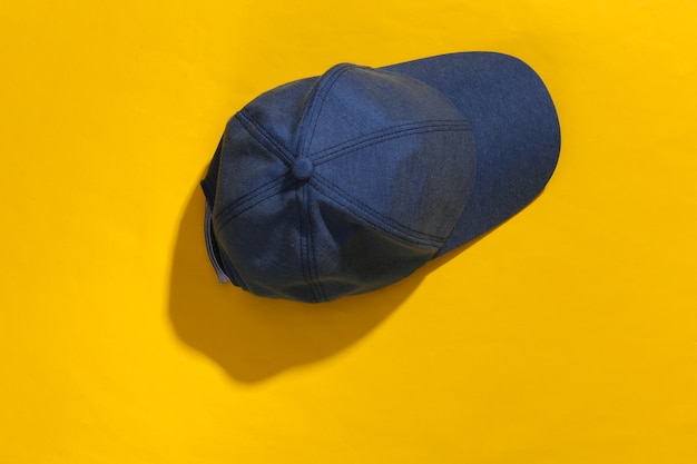 Jeans blue Cap on yellow bright background with deep shadow.