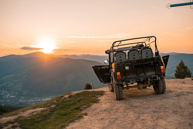 Jeep car at sunset in the mountains landscape