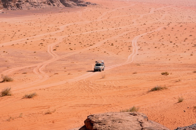 Jeep safari in Wadi Rum desert, Jordan. Tourists in the car ride on off-road on the sand among the rocks