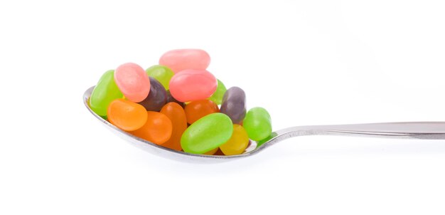 Photo jelly bean candies on spoon isolated on white background