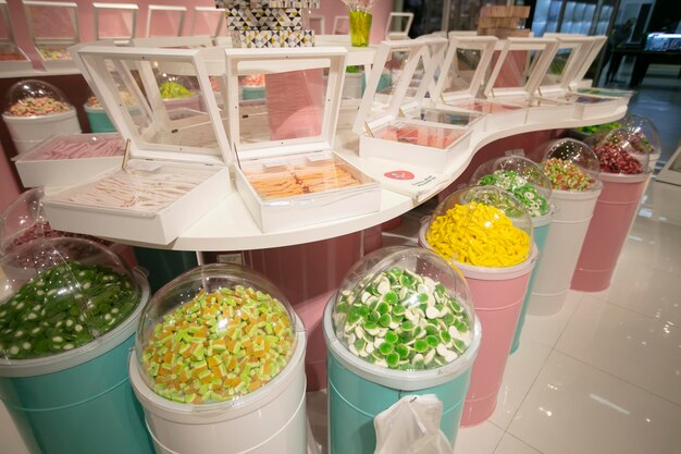 Jelly candies in containers in a store Large selection of sweets in different colors Sale of sweets