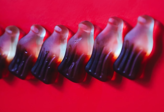 Jelly gummy candies in row in bottle shape close up