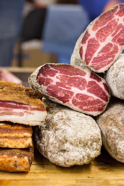 Jerky eef  is cut into two pieces. The fibrous texture of the meat is clearly visible. Meat products and lard are on the counter