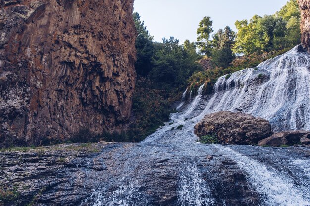 Jermuk waterfall flowing stream picturesque view among the canyon rocks sunlit gorge Armenian stock photo