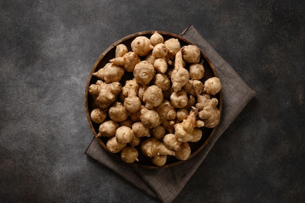 Jerusalem artichoke root sunchokes on dark brown