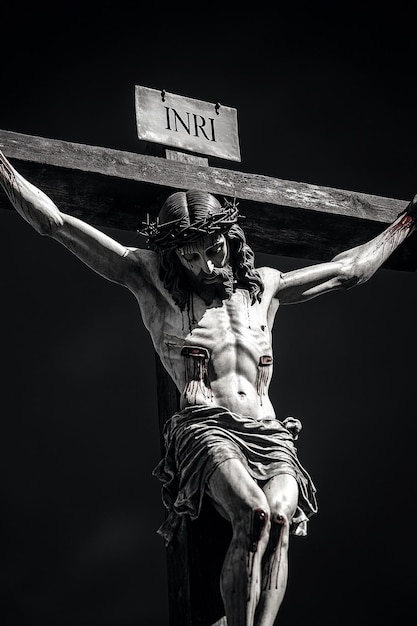 Photo jesus christ on the cross on the plaque at the top of the cross it says inri black background photo ar 23 v 61 job id fe79a7ad635d459c85a64c90128a2f5b