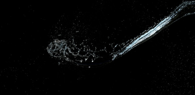 Photo jet of transparent water with small drops and splashes on a black background