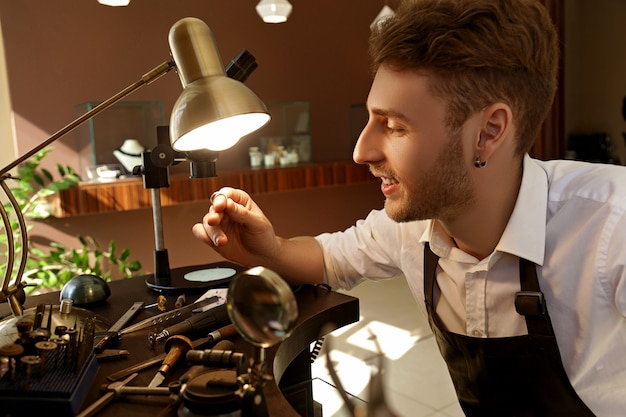 The jeweler examines a ring under the lamp