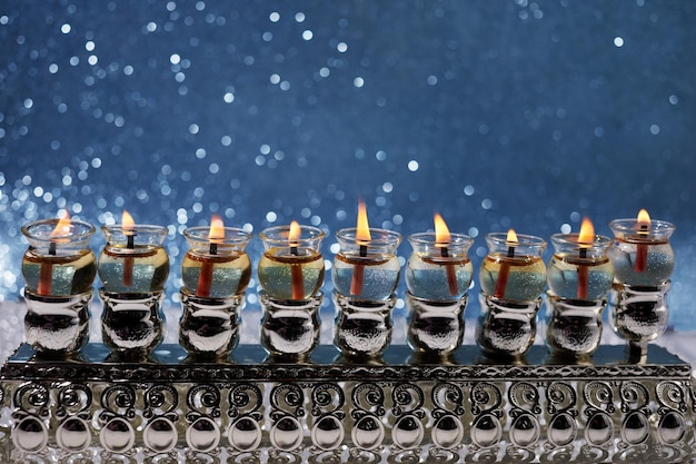 Jewish holiday hanukkah background with menorah traditional candelabra and oil candles