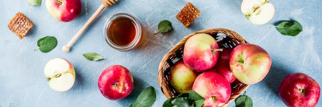 Jewish holiday Rosh Hashanah or apple feast day concept, with red apples, apple leaves and honey in jar