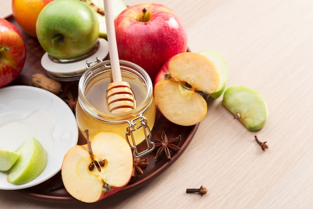 Jewish holiday Rosh Hashanah background with honey and apples on wooden table.