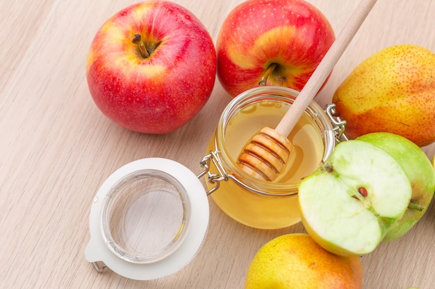 Jewish holiday Rosh Hashanah  with honey and apples on wooden table.