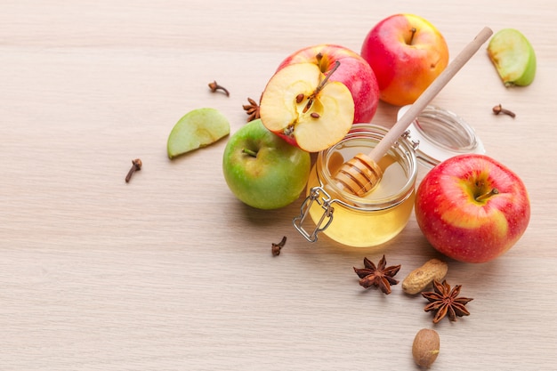 Jewish holiday Rosh Hashanah with honey and apples on wooden table.