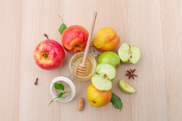 Jewish holiday Rosh Hashanah with honey and apples on wooden table.