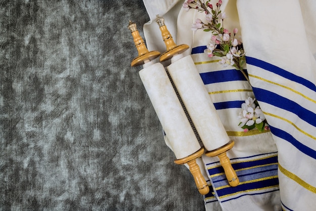 Photo jewish holidays, during prayer items kippa with prayer shawl tallit on torah scroll in a synagogue