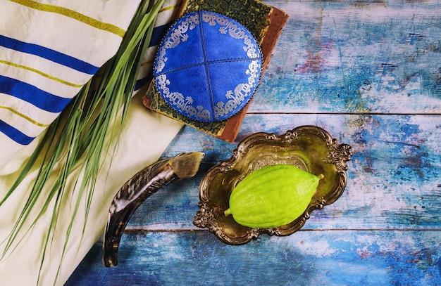 Photo jewish ritual festival of sukkot in the jewish religious symbol etrog, lulav, hadas, arava tallit praying book kippah and shofar