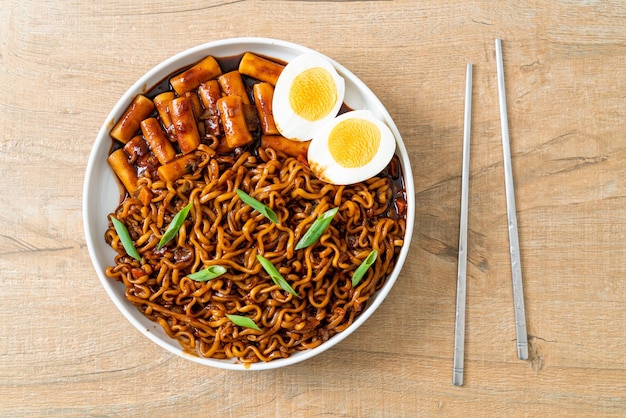 Jjajang Rabokki Korean instant noodles or Ramyeon with Korean rice cake or Tteokbokki and egg in black bean sauce