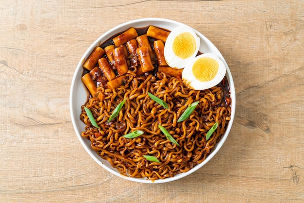 Jjajang Rabokki Korean instant noodles or Ramyeon with Korean rice cake or Tteokbokki and egg in black bean sauce