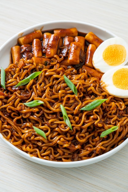 Jjajang Rabokki Korean instant noodles or Ramyeon with Korean rice cake or Tteokbokki and egg in black bean sauce