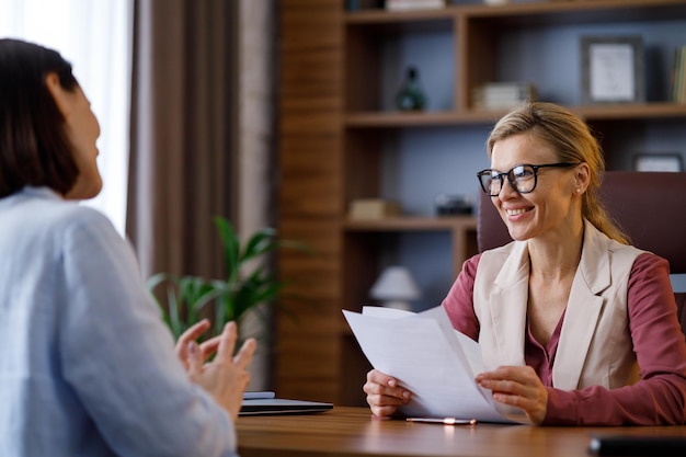 Job interview Female hr manager talking to young candidate Employer and applicant discussing intern professional summary at office meeting Hiring and employment recruitment concept