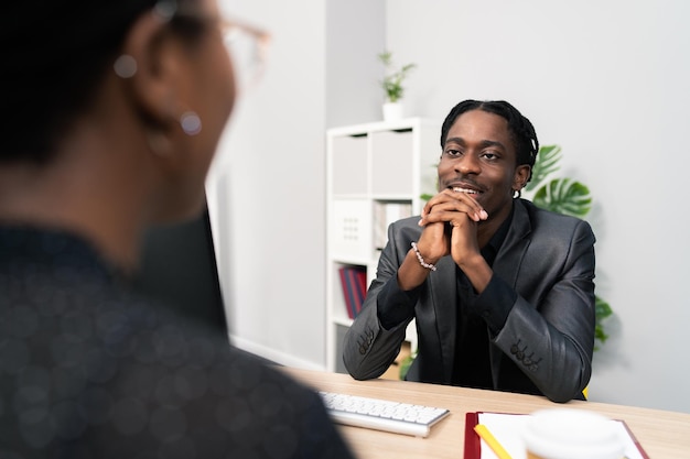 Job interview handsome stern demanding boss sits behind desk in front of computer