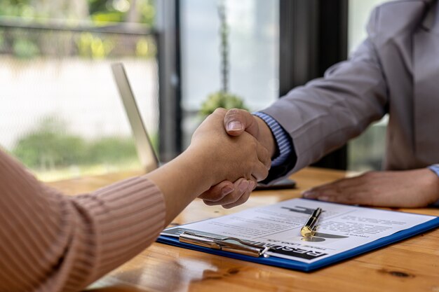 The job interviewer and the job applicant are holding hands after the job interview is finished. The concept of recruiting employees to work in the company, vacant positions.