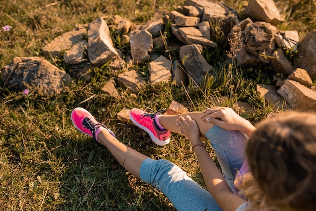 Jogger girl having problems with knee in the forest Sports fitness athlete touching knees with pain