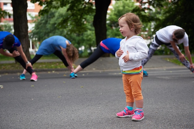 jogging people group, friends have fun with cute little baby gir,  hug and stack hands together after training