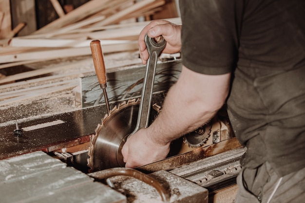 Joinery and wood work concept, professional joiner, carpenter changing saw blade, handcraft and manufacture