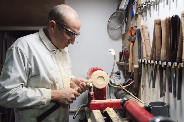 Joinery worker shaping a piece of wood on the lathe